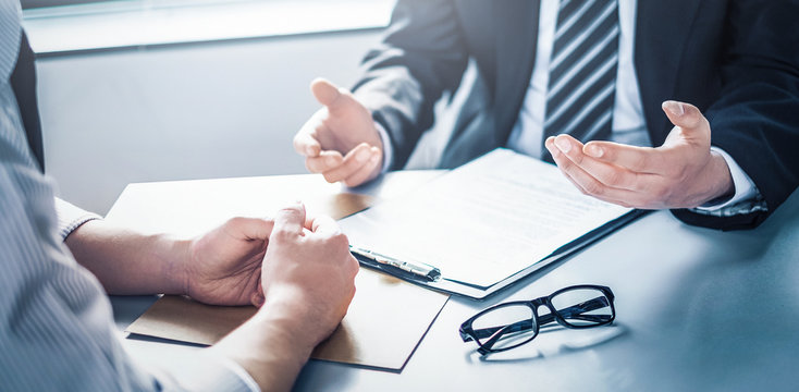 Friendly consultant welcoming a client into the office for a free consultation, with a sign indicating walk-ins are welcome.